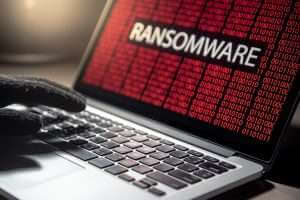 Male,Hacker,Hand,On,Laptop,Computer,Keyboard,With,Red,Binary