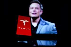 Logo de Tesla y Musk detrás